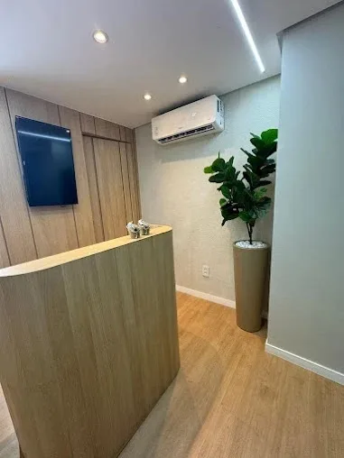 Recepção com balcão de madeira e planta