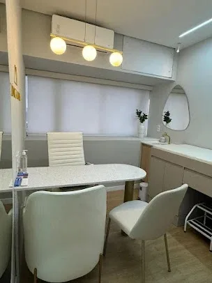 Sala de consulta com mesa branca e cadeiras